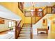 Grand foyer with a striking staircase, soaring ceilings, warm yellow walls, and elegant chandelier at 6761 E Woodland Ct, Mooresville, IN 46158