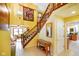 Inviting foyer with a wooden staircase, decorative tapestry, and views into the living room and kitchen at 6761 E Woodland Ct, Mooresville, IN 46158