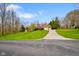 A well-maintained brick home with a three-car garage features a long driveway and lush green lawn at 6761 E Woodland Ct, Mooresville, IN 46158