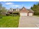 Inviting two-story brick home with a three-car garage and well-manicured lawn and landscaping at 6761 E Woodland Ct, Mooresville, IN 46158