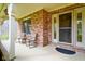 Inviting front porch with brick accents, offering a cozy seating area to relax and enjoy the outdoors at 6761 E Woodland Ct, Mooresville, IN 46158
