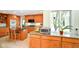 Open kitchen with wood cabinets, a center island with seating, granite countertops, and modern appliances at 6761 E Woodland Ct, Mooresville, IN 46158