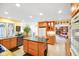 Bright, open-concept kitchen with an island, stainless steel appliances, and views to the living room with fireplace at 6761 E Woodland Ct, Mooresville, IN 46158