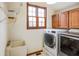 Laundry room featuring front loading washer and dryer, utility sink and window at 6761 E Woodland Ct, Mooresville, IN 46158