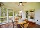 Screened porch with wood flooring, ceiling fan, and table with seating for relaxing at 6761 E Woodland Ct, Mooresville, IN 46158