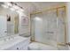 Tiled bathroom with a framed mirror, single sink vanity, toilet, and gold trimmed glass shower doors at 6802 Carters Grove Dr, Noblesville, IN 46062