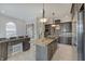 Open-concept kitchen with a central island, a breakfast bar, and stainless steel appliances at 6802 Carters Grove Dr, Noblesville, IN 46062