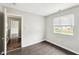 Bedroom with hardwood floors, window, neutral paint, and a door leading to the hallway at 693 Cembra Dr, Greenwood, IN 46143