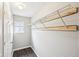 Walk-in closet with shelving unit, window, wood-look flooring, and a white door at 693 Cembra Dr, Greenwood, IN 46143