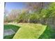 Backyard with a grass lawn is surrounded by a wooden fence and mature trees at 7010 Beargrass Ct, Indianapolis, IN 46241