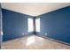 Bedroom with blue walls, neutral carpet, and a window with natural light at 7010 Beargrass Ct, Indianapolis, IN 46241