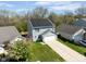 Aerial view features a house with solar panels and an attached garage, surrounded by a green lawn and trees at 7010 Beargrass Ct, Indianapolis, IN 46241
