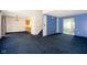 Open concept living room with blue carpet and staircase at 7010 Beargrass Ct, Indianapolis, IN 46241