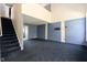 Open concept living room with blue carpet, a staircase and TV mount at 7010 Beargrass Ct, Indianapolis, IN 46241