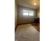 Bedroom with hardwood floors, a light colored rug, a window, and a small dresser with items on top at 7144 Lockwood Ln, Indianapolis, IN 46217