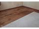 Closeup of hardwood flooring with a light area rug, suitable for a bedroom or living space at 7144 Lockwood Ln, Indianapolis, IN 46217