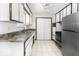 A functional kitchen featuring stainless steel appliances, white cabinets, and tile flooring for a clean, efficient space at 7144 Lockwood Ln, Indianapolis, IN 46217