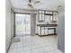 Kitchen with sliding doors to a sunroom, white cabinets, stainless steel refrigerator, and tile floors at 7144 Lockwood Ln, Indianapolis, IN 46217