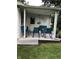 Charming covered porch with stylish outdoor furniture for relaxing, complete with a chandelier for evening ambiance at 7144 Lockwood Ln, Indianapolis, IN 46217