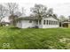 The home's rear exterior features an enclosed sunroom, with an air conditioning unit on the side at 7144 Lockwood Ln, Indianapolis, IN 46217