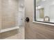Modern bathroom with neutral tile, built-in shower bench, and a sleek vanity mirror at 7210 Covington St, Lebanon, IN 46052