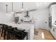 Bright kitchen with white cabinetry, an island with barstool seating, and modern lighting at 7210 Covington St, Lebanon, IN 46052
