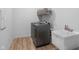 Functional laundry area with modern washer, dryer, utility sink, and shelving at 7210 Covington St, Lebanon, IN 46052