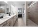 Bathroom with double vanity sinks, walk-in shower with glass door, and wood look tile floor at 7210 Covington St, Lebanon, IN 46052
