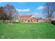Expansive backyard featuring lush green grass, a patio area, and a privacy fence at 7265 Derbyshire Dr, Cumberland, IN 46229