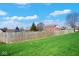Spacious, grassy backyard with a wooden fence, mature trees, and the rear of a brick house at 7265 Derbyshire Dr, Cumberland, IN 46229