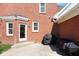 Brick home exterior with back patio area including grill and access door at 7265 Derbyshire Dr, Cumberland, IN 46229