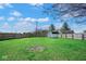 Spacious backyard with a large green area, utility shed, and a secure wooden fence for privacy at 7265 Derbyshire Dr, Cumberland, IN 46229