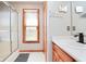 Bathroom with shower, wood trim window, and white countertop at 7265 Derbyshire Dr, Cumberland, IN 46229