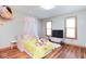 Cozy bedroom with a yellow bed, flower decals, and wood flooring at 7265 Derbyshire Dr, Cumberland, IN 46229