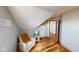 Cozy room featuring sloped ceiling, wood floors, and sitting area with chair and side table at 7265 Derbyshire Dr, Cumberland, IN 46229
