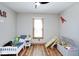 bedroom featuring a ceiling fan, wood floors, and a small bed with a blue blanket at 7265 Derbyshire Dr, Cumberland, IN 46229