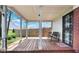 Covered back porch with wood flooring, metal security door, and view of fenced yard at 7265 Derbyshire Dr, Cumberland, IN 46229