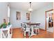 Bright dining area features modern chandelier, hardwood floors, and seating for four at 7265 Derbyshire Dr, Cumberland, IN 46229