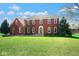 Charming two-story red brick home with a well-manicured lawn and mature trees at 7265 Derbyshire Dr, Cumberland, IN 46229