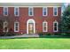 Elegant red brick home featuring a classic arched doorway and manicured front lawn at 7265 Derbyshire Dr, Cumberland, IN 46229