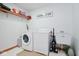 Functional laundry room with white appliances and storage shelf at 7265 Derbyshire Dr, Cumberland, IN 46229