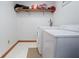 Functional laundry room with white appliances and storage shelf at 7265 Derbyshire Dr, Cumberland, IN 46229
