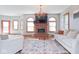Open-concept living room with brick fireplace, modern chandelier, and ample natural light at 7265 Derbyshire Dr, Cumberland, IN 46229