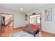 Bright living room with hardwood floors, a comfortable futon, and doorway to the staircase and other rooms at 7265 Derbyshire Dr, Cumberland, IN 46229