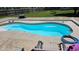 Bright blue kidney-shaped pool with concrete surround, lounge chairs, and fenced-in backyard at 7265 Derbyshire Dr, Cumberland, IN 46229