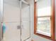 Shower with glass doors and wood trim window at 7265 Derbyshire Dr, Cumberland, IN 46229