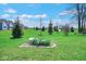 Well-maintained grassy yard with a rock garden, shrubs, and residential neighborhood in background at 7265 Derbyshire Dr, Cumberland, IN 46229