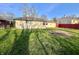 Spacious backyard featuring a lush lawn and a charming red fence, perfect for outdoor activities and privacy at 7606 Miracle Rd, Indianapolis, IN 46237