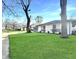 Charming single-story home with a large yard, white painted brick, and a grey two-car garage at 7606 Miracle Rd, Indianapolis, IN 46237