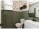 Charming powder room featuring board and batten detail and leaf-patterned wallpaper at 8160 Shaldon Ct, Zionsville, IN 46077